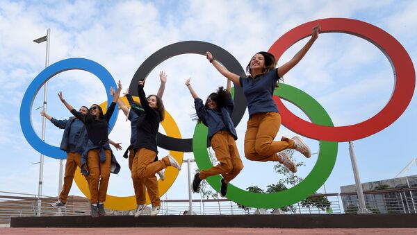 Люди на фоне олимпийских колец в Рио-де-Жанейро  - Sputnik Ўзбекистон