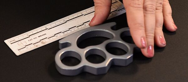 Таможенный эксперт-криминалист демонстрирует кастет. Архивное фото. - Sputnik Узбекистан