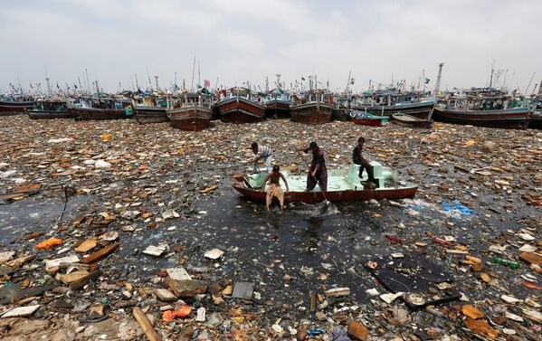Мальчики на лодке собирают мусор для переработки в гавани в Карачи, Пакистан - Sputnik Узбекистан