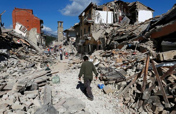 Мужчина  среди развалин после землетрясения в Пескара-дель-Тронто - Sputnik Узбекистан