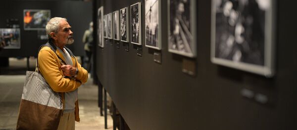 Посетитель на открытии фотовыставки Международного конкурса фотожурналистики имени Андрея Стенина …чтобы знали в Москве - Sputnik Узбекистан