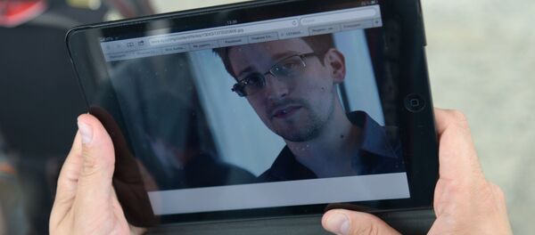 Журналист изучает фото бывшего сотрудника ЦРУ Эдварда Сноудена в аэропорту Шереметьево - Sputnik Узбекистан