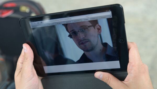 Журналист изучает фото бывшего сотрудника ЦРУ Эдварда Сноудена в аэропорту Шереметьево - Sputnik Узбекистан