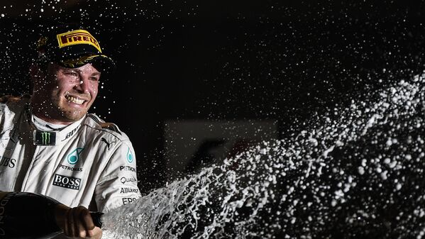 Немецкий пилот Mercedes AMG Petronas F1 Team Нико Росберг празднует победу  после ночной гонки Гран При в Сингапуре - Sputnik Узбекистан