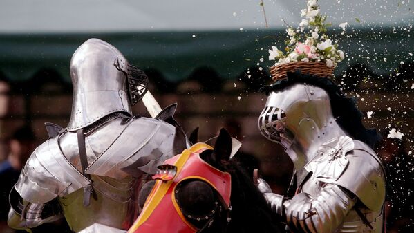 Австралийский рыцарь Филипп Лейч разбивает горшок с цветами на шлеме противника, во время средневековой ярмарки в Сиднее - Sputnik Узбекистан