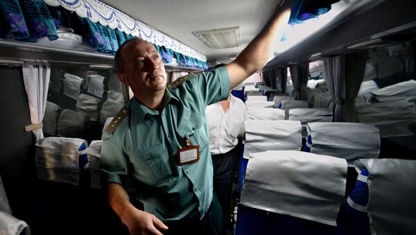 Сотрудник таможни осматривает автобус - Sputnik Узбекистан