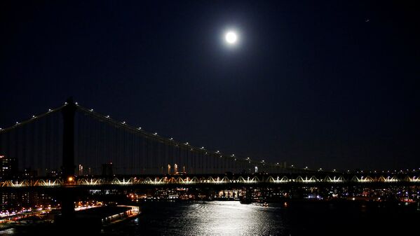 Полная Луна видна над Манхэттенским мостом накануне суперлуния в Нью-Йорке. - Sputnik Узбекистан