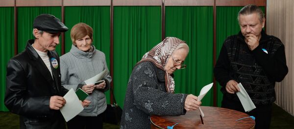 Женщина голосует на избирательном участке в Ташкенте во время выборов президента Узбекистана - Sputnik Узбекистан