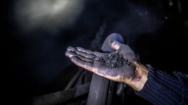 Шахтер показывает уголь. Архивное фото - Sputnik Ўзбекистон