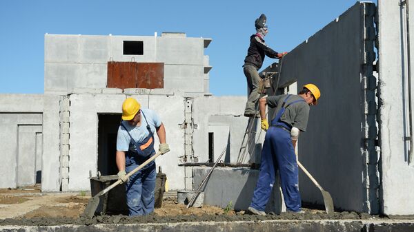 Строители осуществляют монтаж стеновых панелей цокольного этажа многоквартирного жилого дома - Sputnik Узбекистан