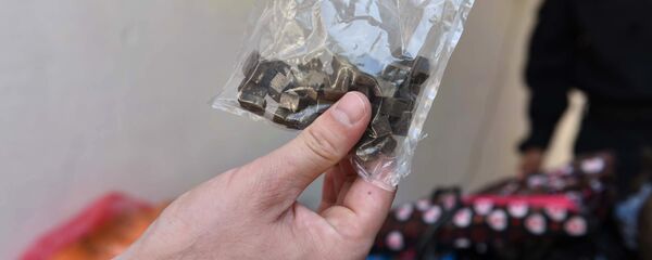 Сотрудник правоохранительных органов демонстрирует пакет с наркотиками - Sputnik Узбекистан