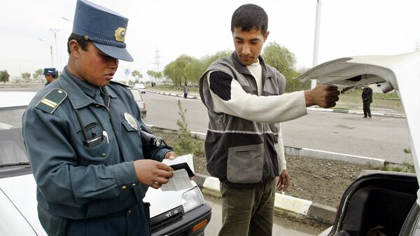 Сотрудник милиции осматривает автомобиль - Sputnik Узбекистан