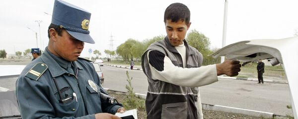 Сотрудник милиции осматривает автомобиль Сотрудник милиции осматривает автомобиль - Sputnik Ўзбекистон