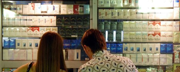 Молодые люди выбирают сигареты в табачном ларьке Молодые люди выбирают сигареты в табачном ларьке - Sputnik Ўзбекистон