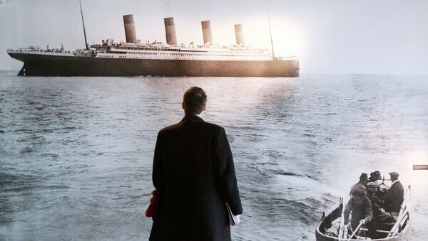 Мужчина смотрит на фотографию, на которой изображен Титаник - Sputnik Узбекистан