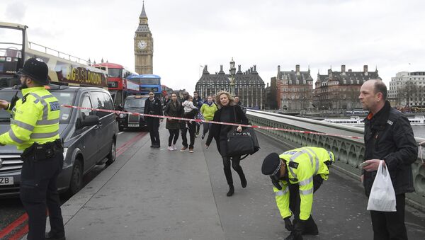A woman ducks under a police tape after an incident on Westminster Bridge in London - Sputnik Узбекистан