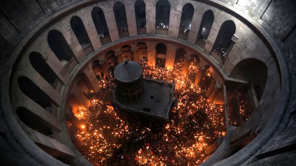 Христианские православные молящиеся зажигают свечи от Благодатного огня в церкви Гроба Господня в Старом городе Иерусалима - Sputnik Узбекистан