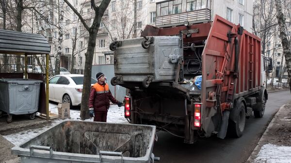Сотрудник коммунальных служб выгружает мусор - Sputnik Узбекистан