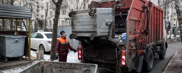 Сотрудник коммунальных служб выгружает мусор Сотрудник коммунальных служб выгружает мусор - Sputnik Ўзбекистон