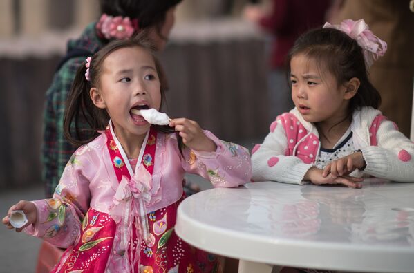 Дети едят мороженое в Центральном зоопарке Пхеньяна - Sputnik Узбекистан