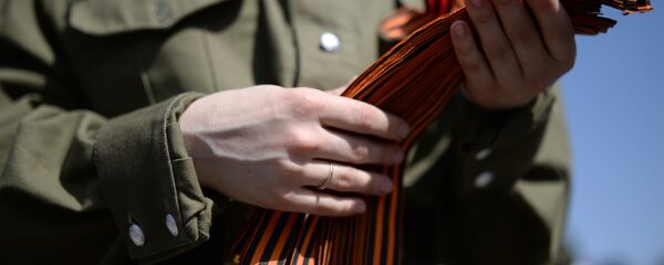 Георгий лентасини тарқатаётган волонтёр Георгий лентасини тарқатаётган волонтёр - Sputnik Ўзбекистон