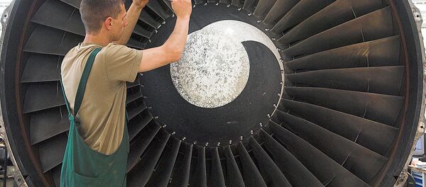 Сотрудник проводит техническое обслуживание двигателя самолета Сотрудник проводит техническое обслуживание двигателя самолета - Sputnik Ўзбекистон