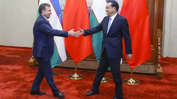 Премьер Государственного совета КНР Ли Кэцян (справа) приветствует президента Узбекистана Шавката Мирзиёева - Sputnik Узбекистан