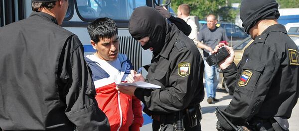 Сотрудник ОМОН регистрируют задержанного во время рейда на одном из рынков Сотрудник ОМОН регистрируют задержанного во время рейда на одном из рынков - Sputnik Ўзбекистон