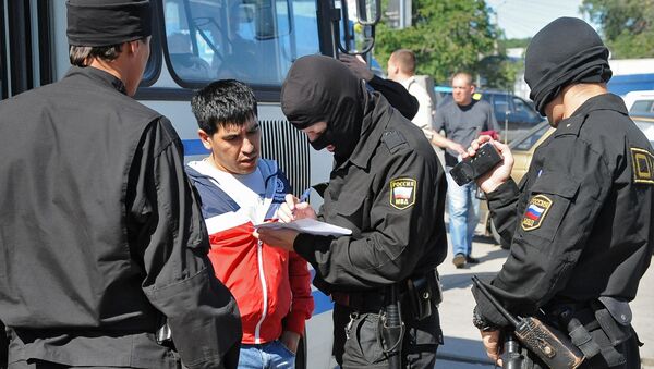 Сотрудник ОМОН регистрируют задержанного во время рейда на одном из рынков - Sputnik Узбекистан