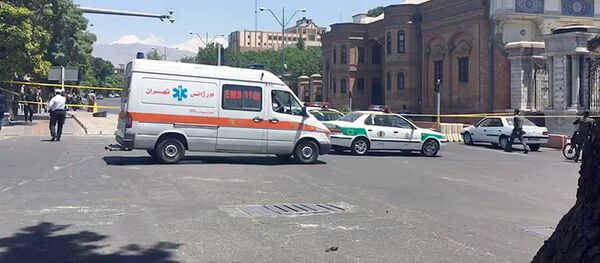 Полицейские машины и машина скорой помощи около места нападения террористов в Тегеране - Sputnik Узбекистан
