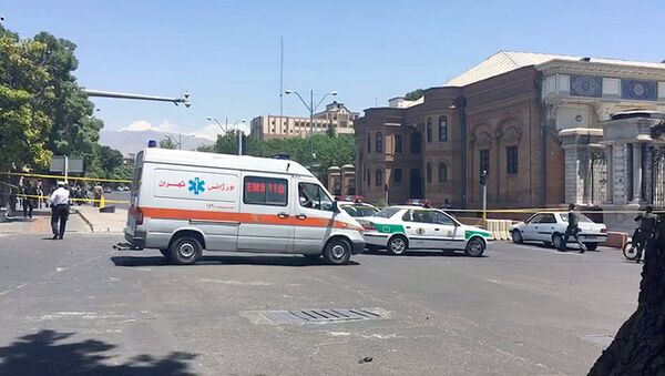 Полицейские машины и машина скорой помощи около места нападения террористов в Тегеране - Sputnik Узбекистан