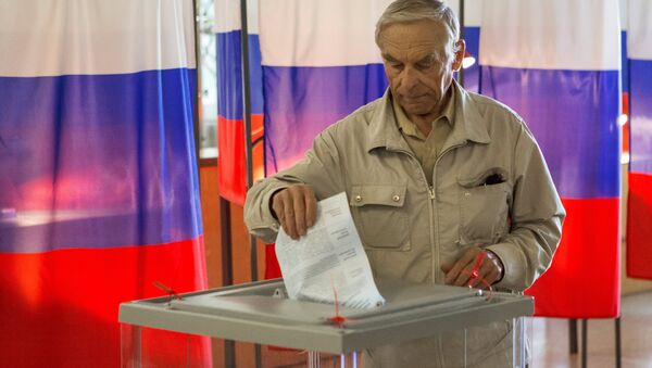 Избиратель опускает бюллетень в урну - Sputnik Узбекистан