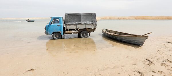 Fishermen ride in a truck to collect fish from a boat in shallow water by the Aral Sea, outside the village of Karateren, south-western Kazakhstan, April 15, 2017. Akespe, home to some 250 people, and Karateren, inhabited by about 150, used to be dominated by fishermen until the water receded too far away - but it is now back in Karateren Fishermen ride in a truck to collect fish from a boat in shallow water by the Aral Sea, outside the village of Karateren, south-western Kazakhstan, April 15, 2017. Akespe, home to some 250 people, and Karateren, inhabited by about 150, used to be dominated by fishermen until the water receded too far away - but it is now back in Karateren - Sputnik Узбекистан
