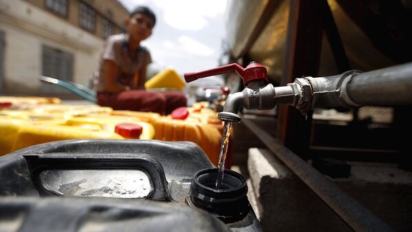 В столице Сане йеменский мальчик заполняет канистру питьевой водой из подаренных баков, 2 июля 2017 года - Sputnik Узбекистан