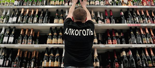 Продавец расставляет на полках бутылки шампанского вина Продавец расставляет на полках бутылки шампанского вина - Sputnik Ўзбекистон