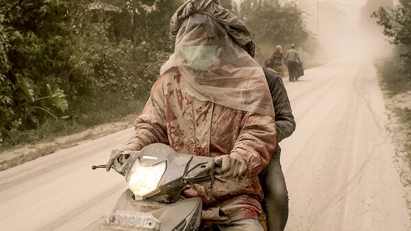 Мотоциклисты спасают свои лица от пепла после извержения вулкана Синабунг на Суматре - Sputnik Узбекистан