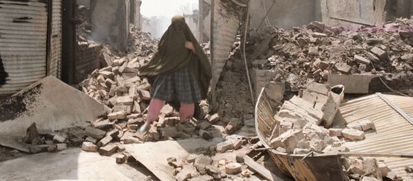 Местная жительница на разрушенной улице Кундуза Местная жительница на разрушенной улице Кундуза - Sputnik Узбекистан