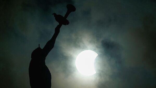 The Anjo Moroni statue atop the church of the Mormons is photographed while the solar eclipse is seen in Manaus - Sputnik Узбекистан