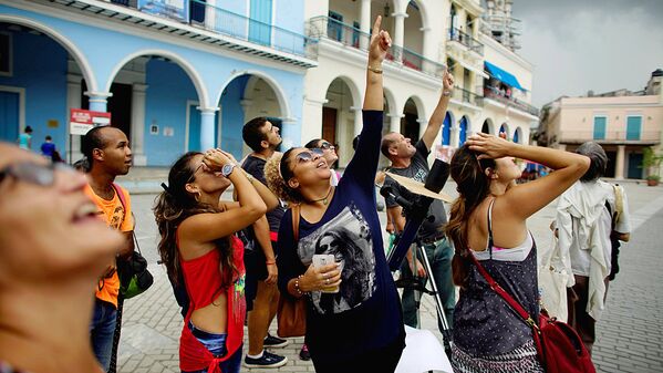 People look towards the sky as enthusiasts gather in Old Havana for the partial solar eclipse in Cuba - Sputnik Узбекистан