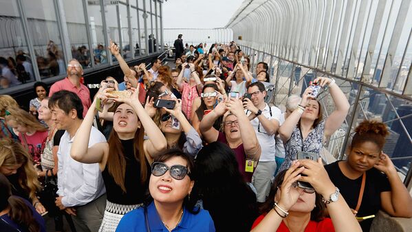 People watch the solar eclipse from the observation deck of The Empire State Building in New York - Sputnik Узбекистан