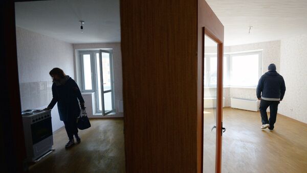 Мужчина и женщина осматривают свою квартиру в новом жилом доме - Sputnik Ўзбекистон