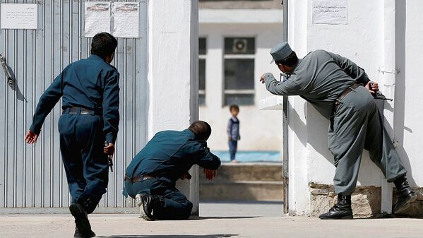 Афганские полицейские пытаются спасти четырехлетнего Али Ахмада во время столкновения между афганскими силами и боевиками после нападения на шиитскую мечеть в Кабуле, Афганистан - Sputnik Узбекистан