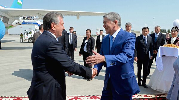 Президент Кыргызстана Алмазбек Атамбаев приветствует узбекского лидера в аэропорту Манас - Sputnik Узбекистан