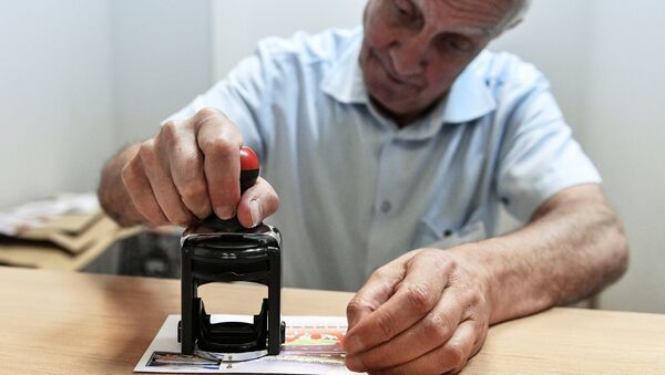Мужчина ставит печать на почтовый конверт - Sputnik Узбекистан