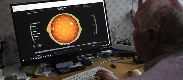 Сотрудник рассматривает модель солнечной активности Сотрудник рассматривает модель солнечной активности - Sputnik Узбекистан