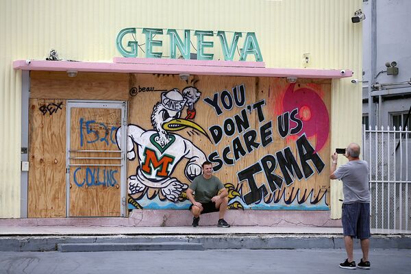 Турист позирует у граффити против Ирмы во Флориде - Sputnik Узбекистан