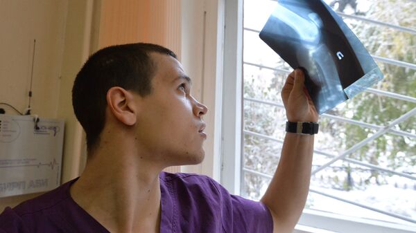 Врач-травматолог смотрит на рентгеновский снимок - Sputnik Ўзбекистон