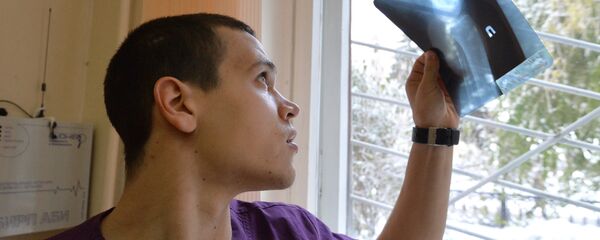 Врач-травматолог смотрит на рентгеновский снимок Врач-травматолог смотрит на рентгеновский снимок - Sputnik Ўзбекистон