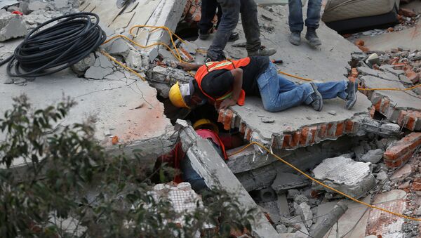 Rescue personnel search for people among the rubble of a collapsed building after an earthquake hit Mexico City, Mexico September 19, 2017 - Sputnik Узбекистан