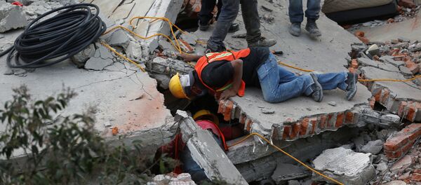 Rescue personnel search for people among the rubble of a collapsed building after an earthquake hit Mexico City, Mexico September 19, 2017 - Sputnik Узбекистан